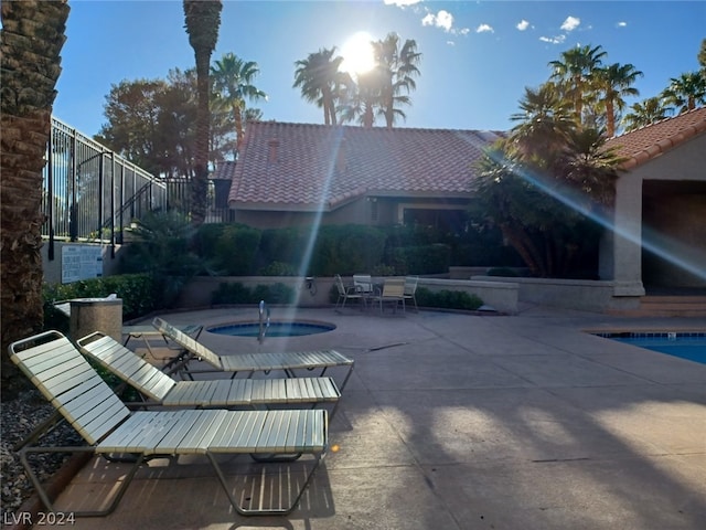 view of terrace with a pool with hot tub