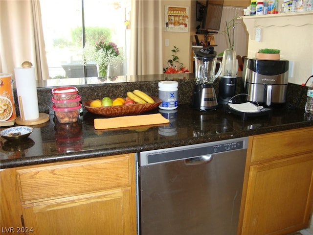 kitchen featuring dark stone countertops and dishwasher