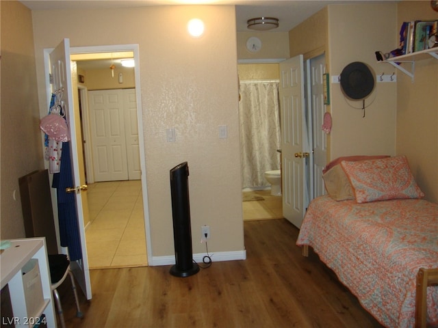 bedroom featuring ensuite bathroom and hardwood / wood-style floors