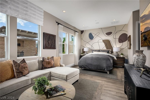 bedroom featuring light hardwood / wood-style floors and a fireplace