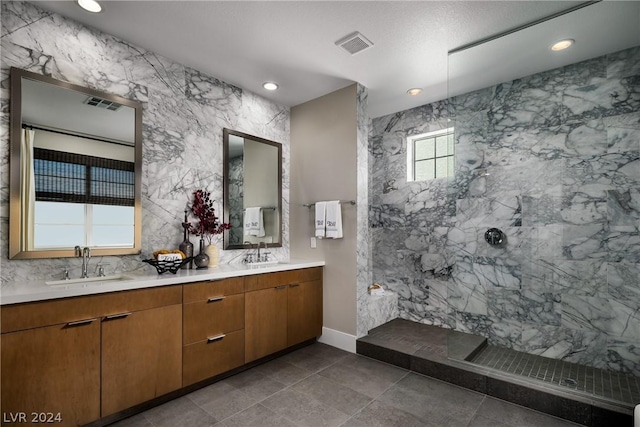 bathroom featuring a tile shower and vanity