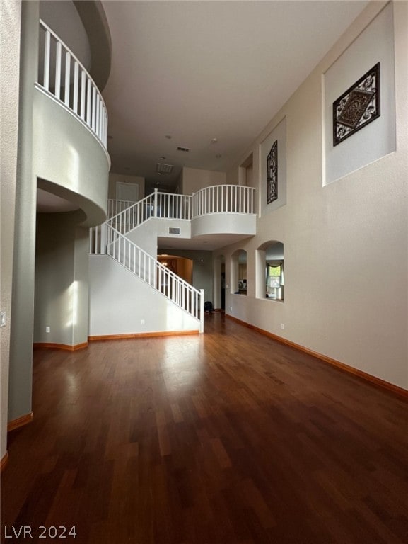 unfurnished room featuring a high ceiling and hardwood / wood-style floors