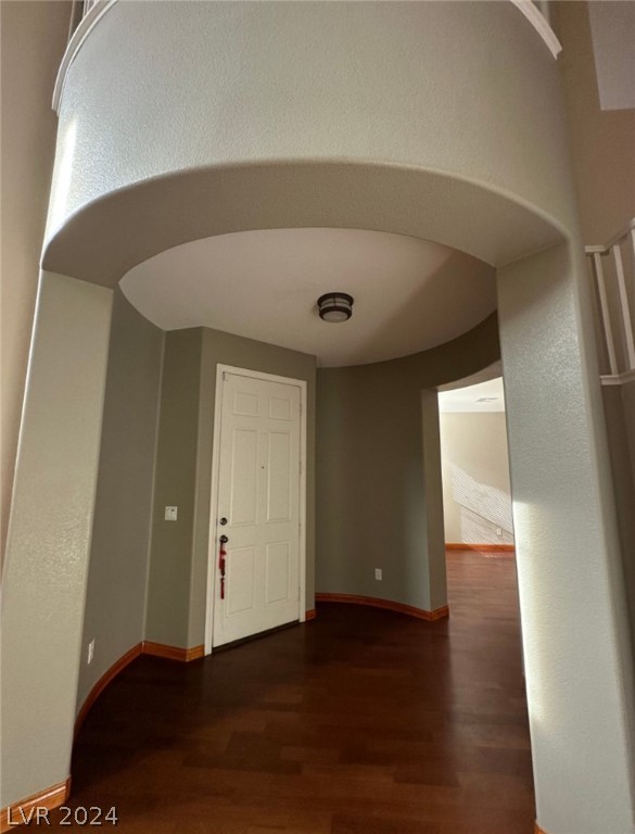 unfurnished room with dark wood-type flooring