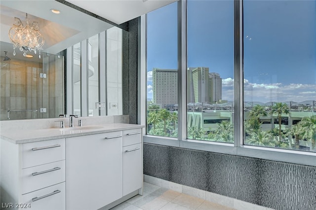 bathroom featuring an inviting chandelier, tile patterned flooring, walk in shower, and vanity