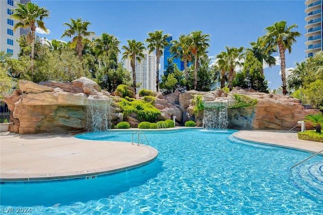 view of swimming pool with pool water feature