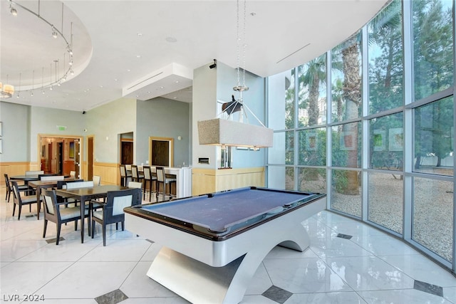 playroom featuring a towering ceiling, billiards, and expansive windows