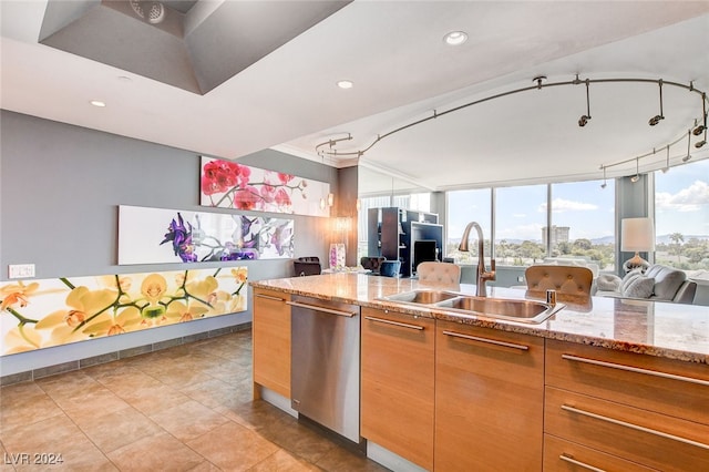 kitchen featuring light tile patterned floors, light stone countertops, sink, and stainless steel dishwasher