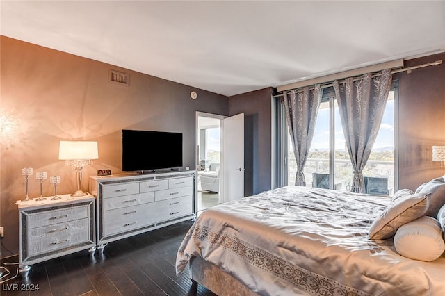 bedroom featuring multiple windows and dark hardwood / wood-style flooring