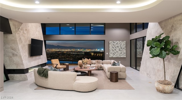 living room with tile walls, a tray ceiling, and tile patterned floors