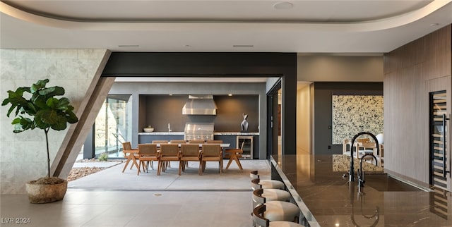 dining space featuring sink, beverage cooler, and a tray ceiling