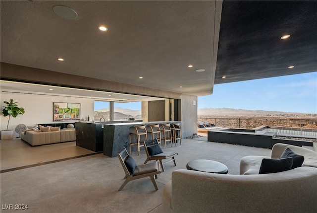 view of patio featuring a mountain view, an outdoor living space, and an outdoor bar