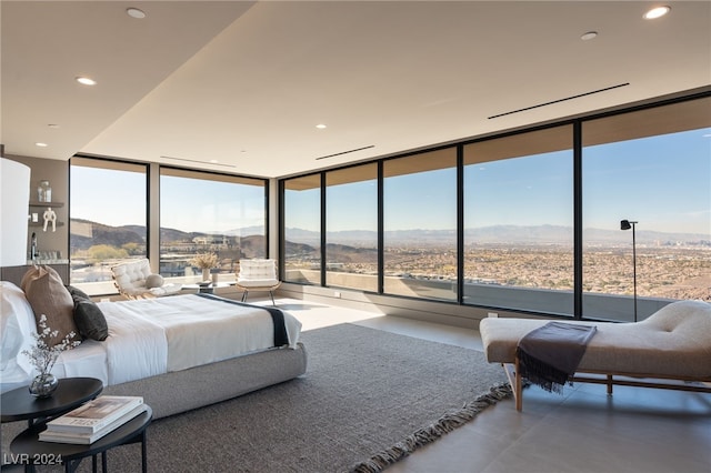 bedroom featuring a wall of windows and a mountain view