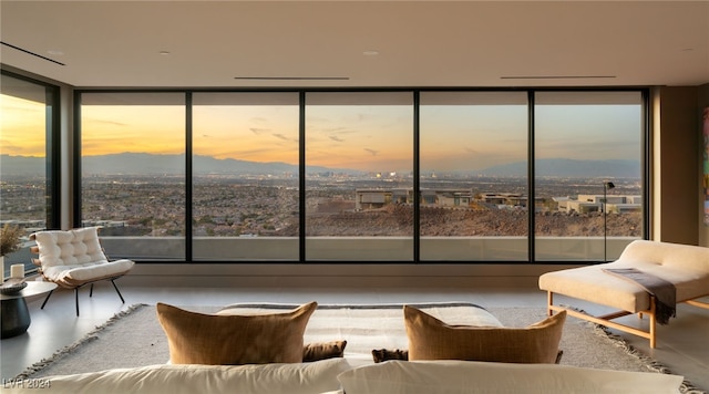 living room with concrete flooring, floor to ceiling windows, and a healthy amount of sunlight