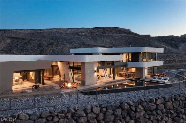 rear view of house featuring a mountain view, a fire pit, and a patio