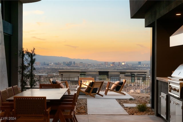 balcony at dusk featuring a patio