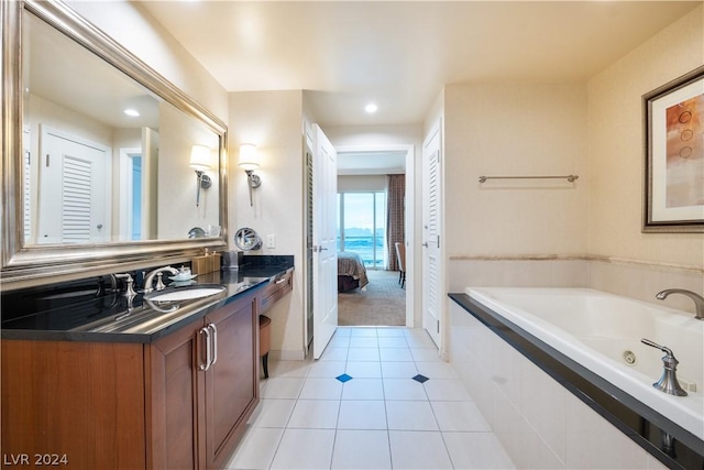 bathroom featuring tile patterned floors, vanity, and tiled tub