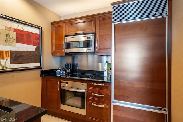 kitchen with dark stone countertops and stainless steel appliances