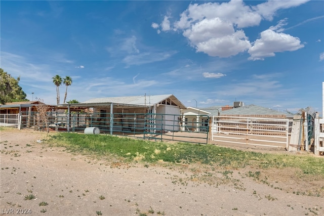 view of stable featuring an outdoor structure and a rural view