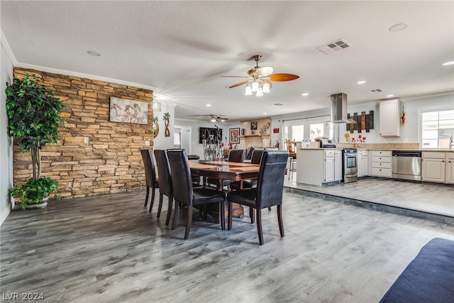 dining room featuring hardwood / wood-style flooring, ceiling fan, a textured ceiling, and crown molding