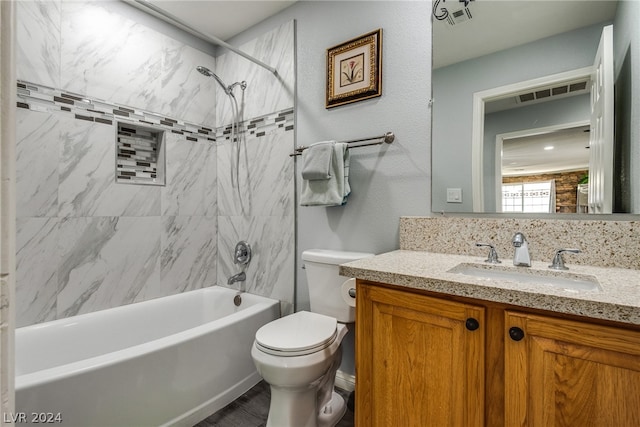 full bathroom with tiled shower / bath, toilet, and vanity