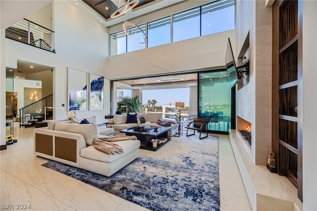 living area with a healthy amount of sunlight, marble finish floor, and stairway