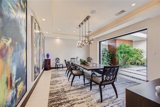 dining area featuring hardwood / wood-style floors, a chandelier, a raised ceiling, and rail lighting