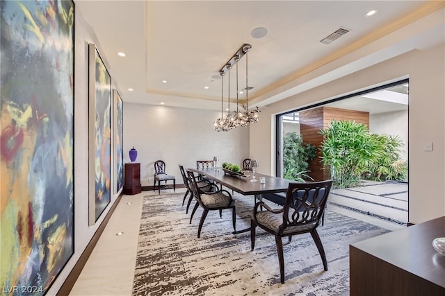 dining space with a chandelier, a raised ceiling, visible vents, and recessed lighting