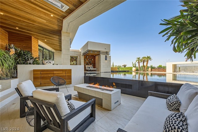 view of patio / terrace with a water view and an outdoor living space with a fire pit