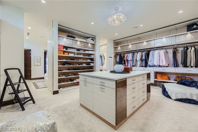 spacious closet featuring an inviting chandelier and light colored carpet