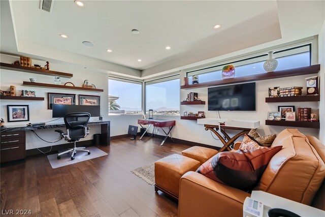 office area with a tray ceiling and dark hardwood / wood-style flooring