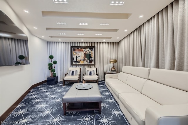 carpeted living room with baseboards, a raised ceiling, and recessed lighting