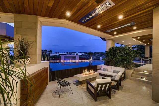 patio terrace at dusk with an outdoor living space with a fire pit