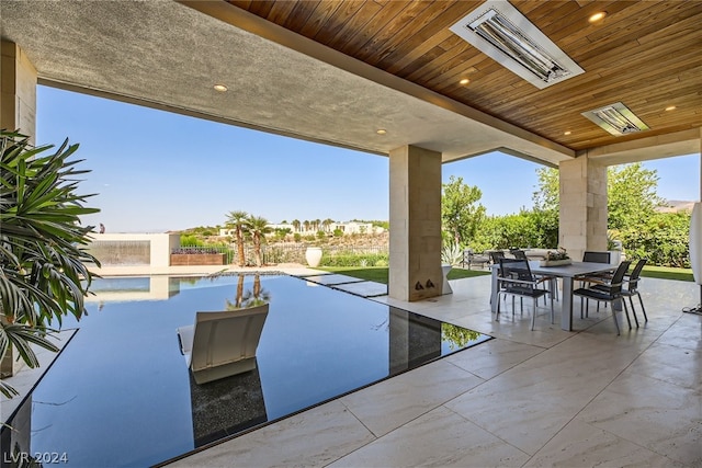 view of patio / terrace featuring outdoor dining area and an outdoor pool