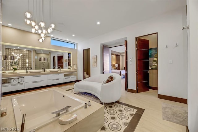 bathroom with recessed lighting, vanity, a chandelier, a freestanding tub, and baseboards