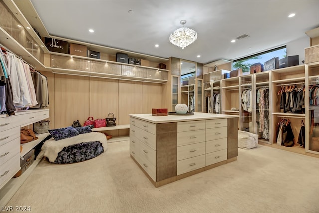 walk in closet featuring an inviting chandelier and light colored carpet