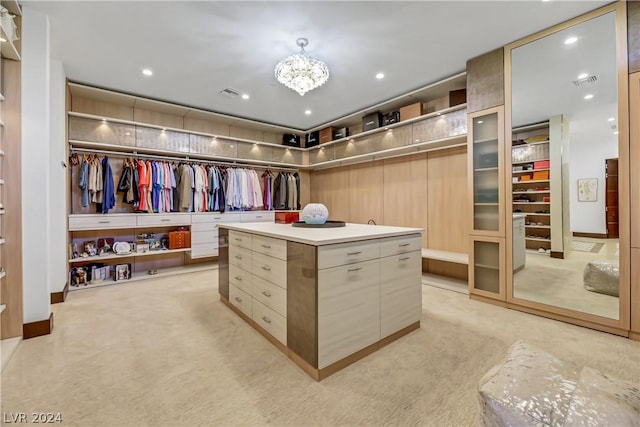 spacious closet with light carpet, visible vents, and an inviting chandelier