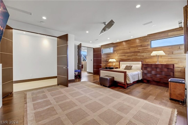 unfurnished bedroom with recessed lighting, visible vents, wood walls, wood finished floors, and baseboards