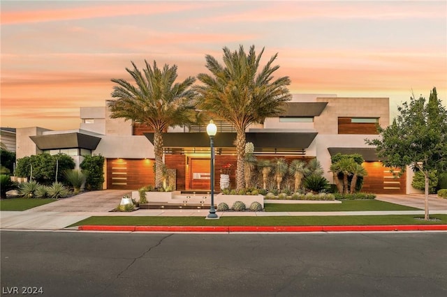 view of front of house featuring a garage, concrete driveway, and stucco siding