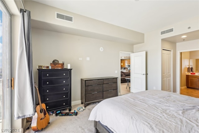 bedroom with light carpet and ensuite bath