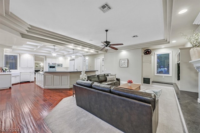 living room with dark hardwood / wood-style floors, coffered ceiling, ceiling fan, and a tray ceiling