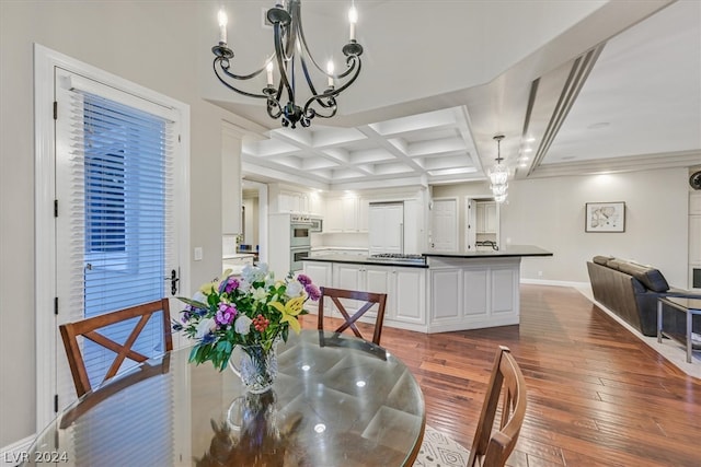 dining room featuring dark wood-type flooring, coffered ceiling, a chandelier, and beam ceiling