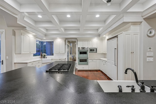 kitchen featuring dark hardwood / wood-style flooring, coffered ceiling, stainless steel appliances, tasteful backsplash, and sink