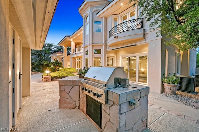 view of patio / terrace with a grill, an outdoor kitchen, and a balcony