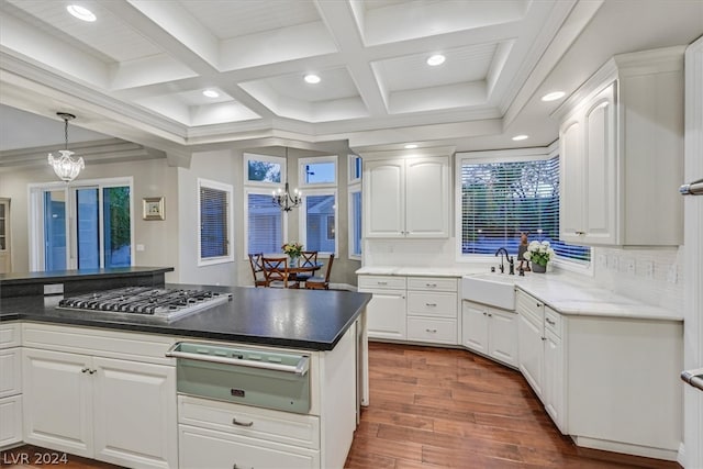 kitchen with a notable chandelier, white cabinets, backsplash, and coffered ceiling