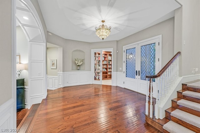 foyer entrance with an inviting chandelier, hardwood / wood-style floors, and french doors