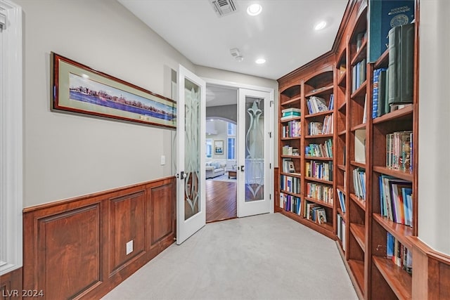 living area featuring french doors and light carpet