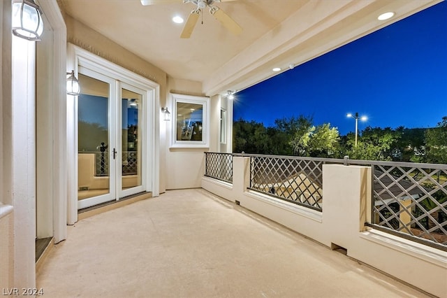 balcony at night with ceiling fan and french doors