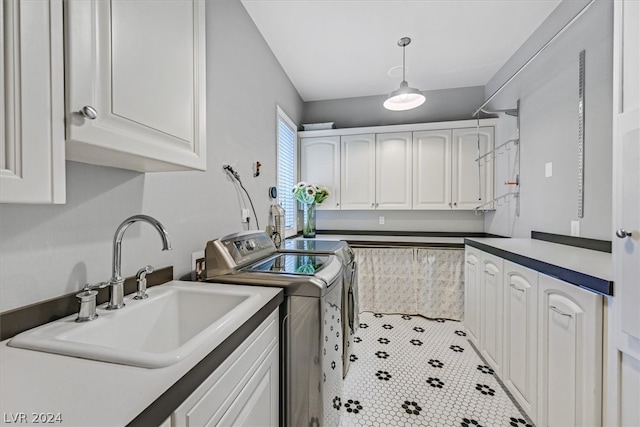 washroom with tile floors, independent washer and dryer, sink, and cabinets