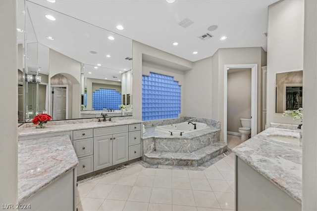 bathroom with tile flooring, a bidet, tiled bath, toilet, and vanity