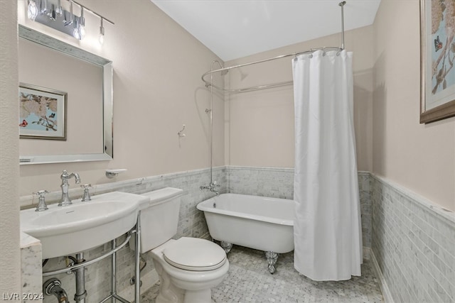 bathroom with tile flooring, sink, tile walls, and toilet